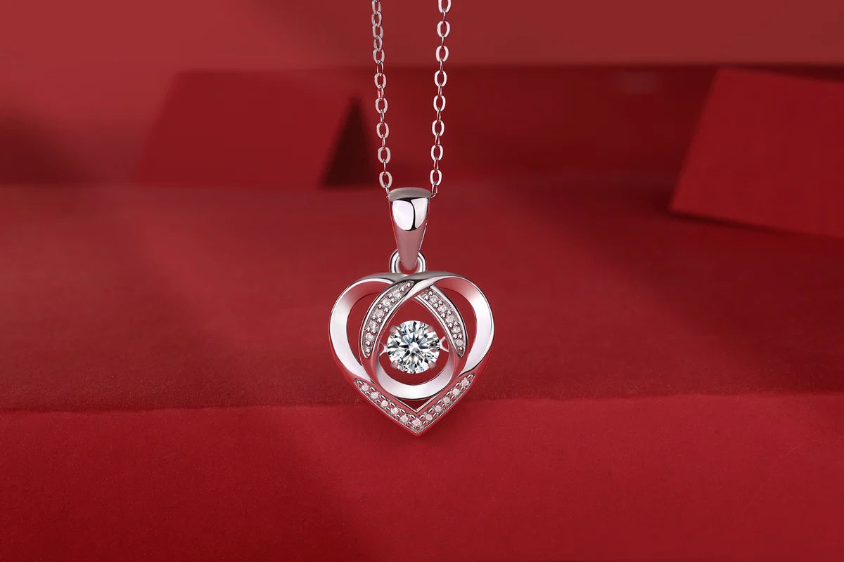 Silver heart-shaped pendant with a diamond on a red background