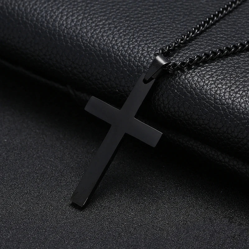 Black cross pendant necklace on a black leather surface