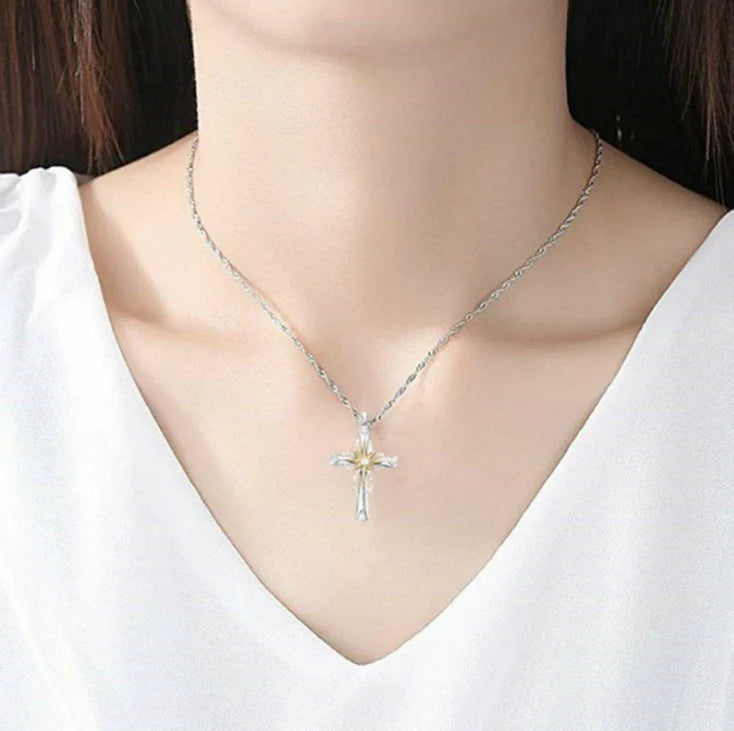 Silver cross necklace on a white shirt