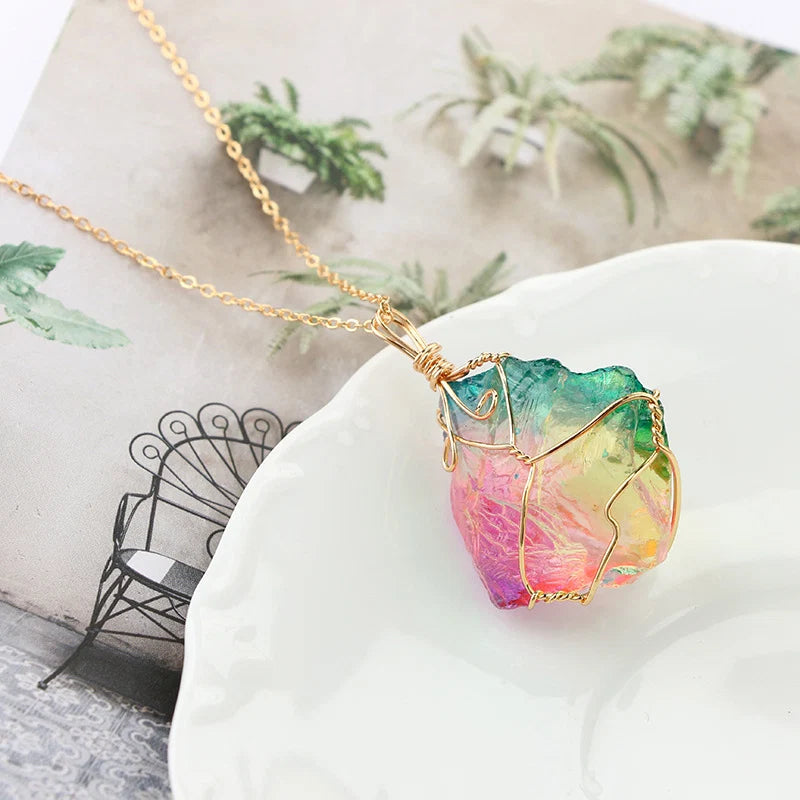 Colorful crystal pendant necklace on a white surface with a blurred background
